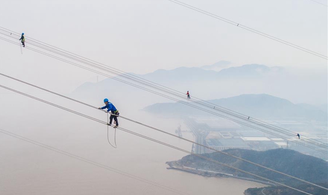 World's highest power supply pylons complete cable construction in Zhoushan, E China's Zhejiang