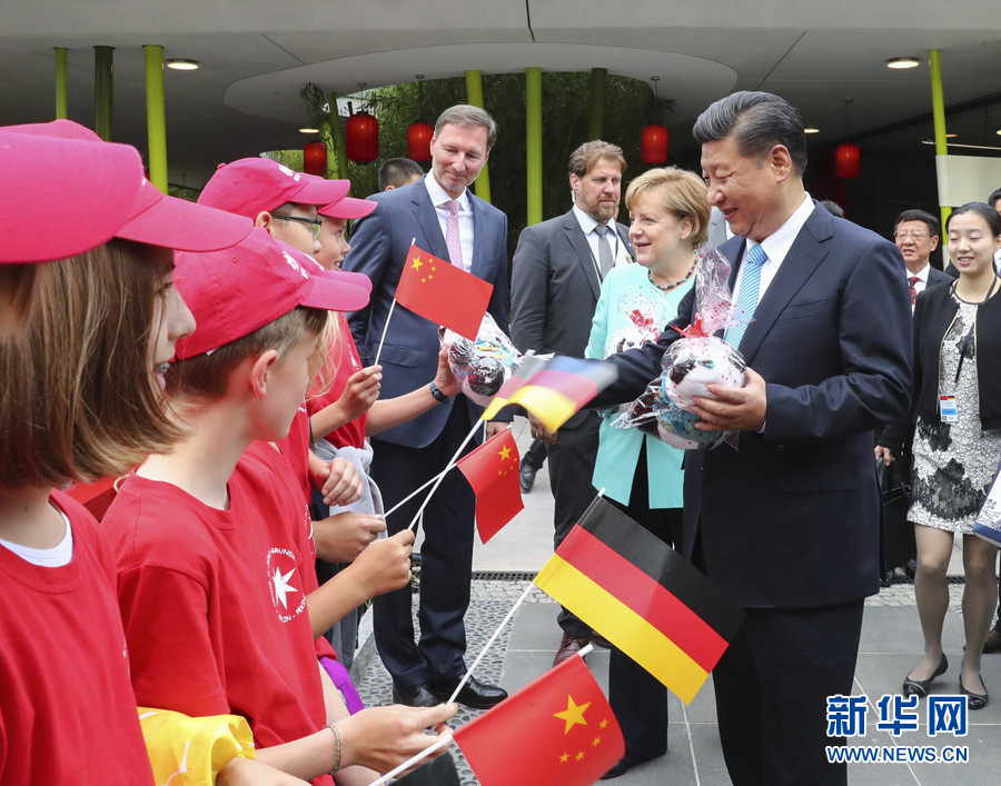 7月5日，国家主席习近平同德国总理默克尔共同出席柏林动物园大熊猫馆开馆仪式。这是习近平向现场的孩子们赠送大熊猫毛绒玩具。 新华社记者谢环驰 摄